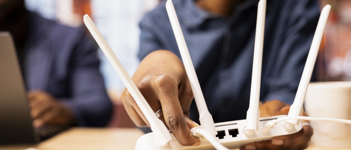 Black couple at home examine the modem setup and troubleshooting online guides Black woman and man rebooting the WI FI router by moving the cables, troubleshooting to restore the internet connection. Freelancers at home struggling with signal loss or lag.